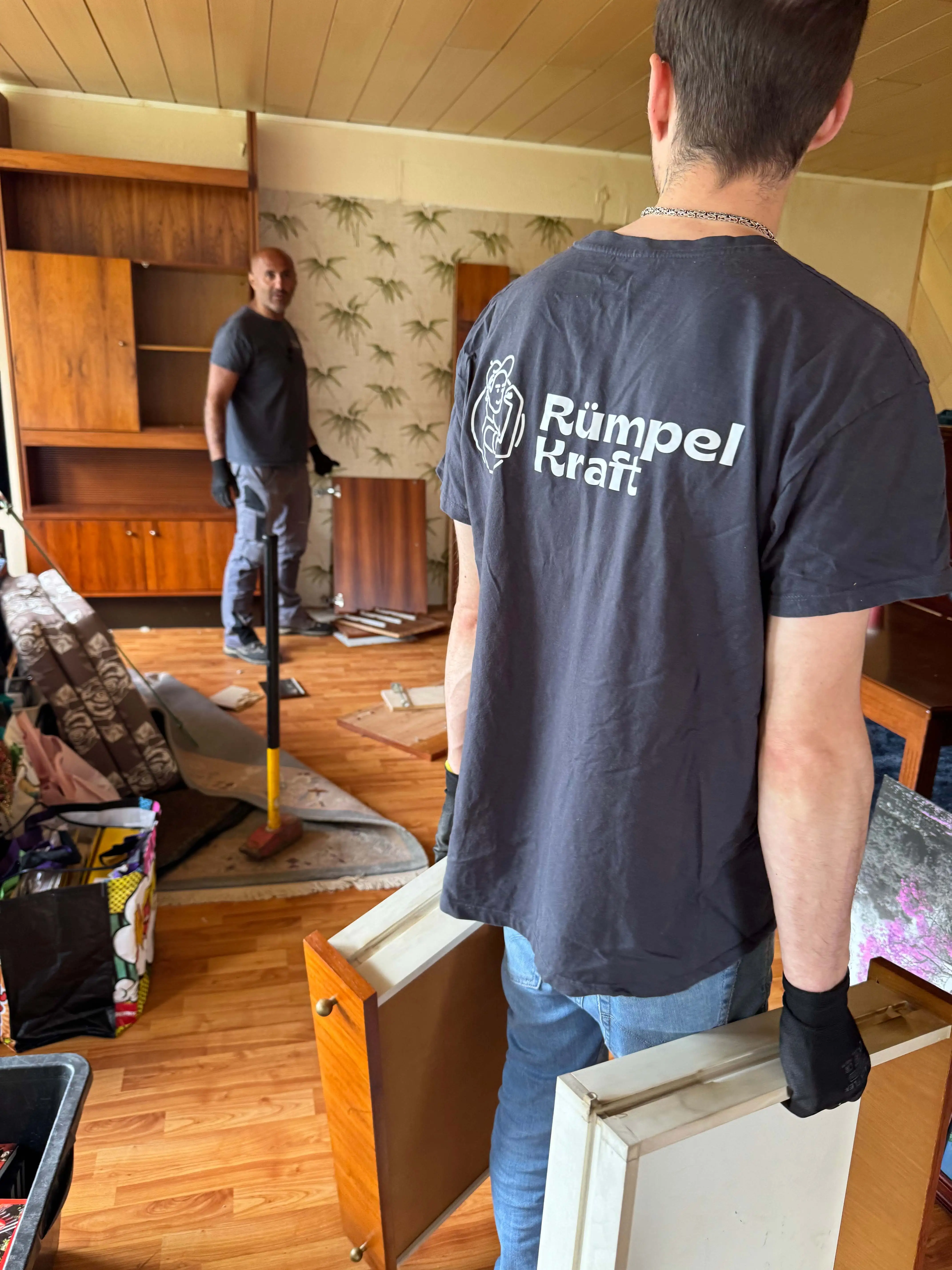 Mitarbeiter von Rümpelkraft räumen ein Wohnzimmer aus